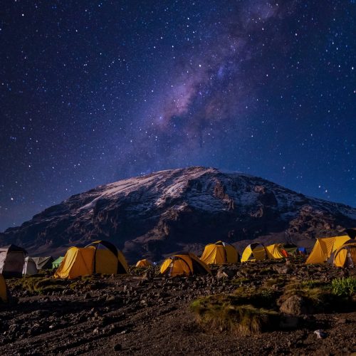 Beautiful scenery of yellow tents in the Kilimanjaro National Park A beautiful scenery of yellow tents in the Kilimanjaro National Park